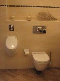 Urinal und WC in weiß an sandfarben gefliester Wand, Bodenfliesen braun meliert Urinal und WC in weiß an sandfarben gefliester Wand, Bodenfliesen braun meliert